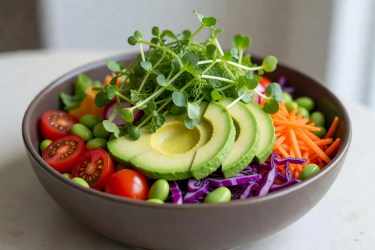 Colorful healthy salad bowl topped with fresh microgreens and avocado slices